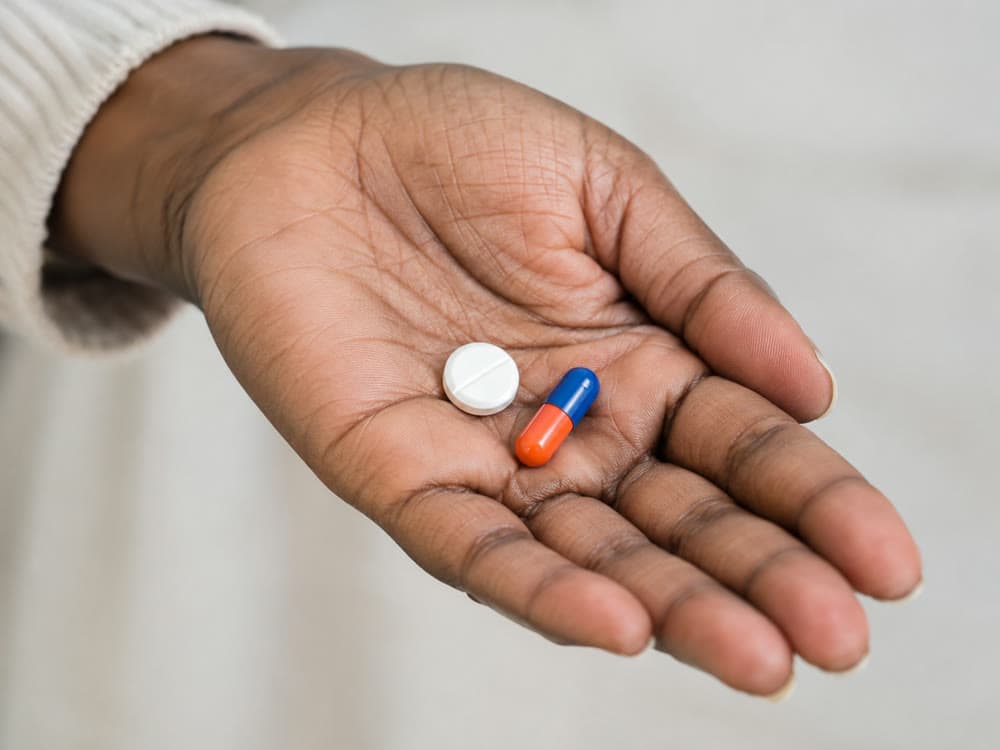 Two different medications held in a patient's palm
